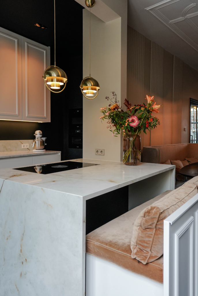 Prachtige maatwerkbank in een keukeneiland. Als deze gesloten is lijkt het eiland een strak blok, met lijstwerk aan de buitenzijde. Bij het openen van de bank tref je een warme tabakskleurige velvetstof aan. Een comfortabele bank.