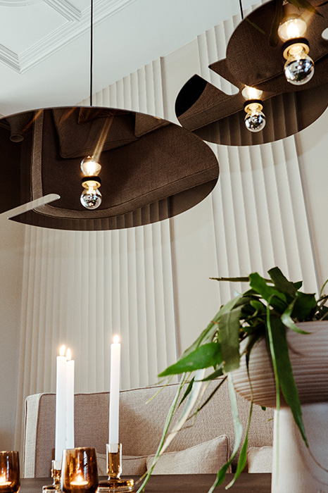 Drie hanglampen van Wever & Ducré op verschillende hoogtes boven de eettafel gepositioneerd om een spannend aanzicht te krijgen